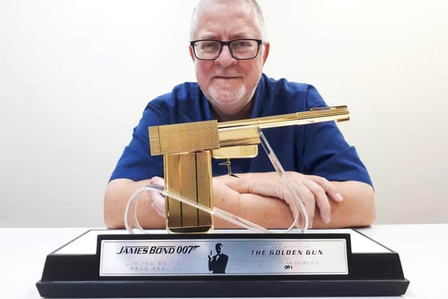 Tony Swift with the golden gun, which is coming up for auction.