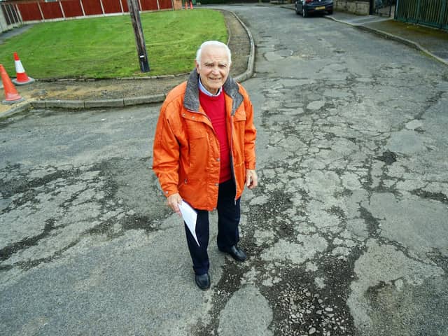 John Scott standing next to potholes on Glebe Close, Holmewood.