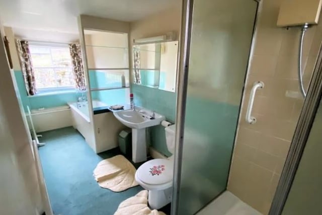 A four-piece suite in white comprises bath, shower cubicle, wash basin and wc.