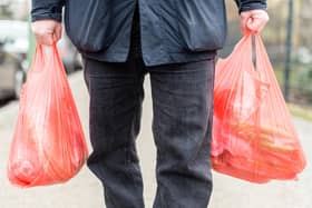 A man carrying his purchases in plastic bags. Credit: SEBASTIAN GOLLNOW/DPA/AFP via Getty Images.