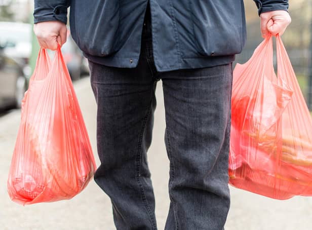 A man carrying his purchases in plastic bags. Credit: SEBASTIAN GOLLNOW/DPA/AFP via Getty Images.