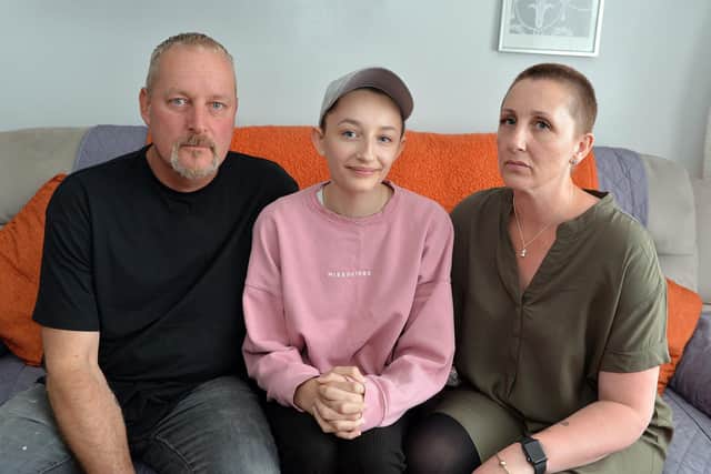 Ella Goodwin, 13, seen with parents Shaun and Joanne has lost her hair due to illness. She doesn't want to wear a wig but is being told she cannot wear a cap to school.