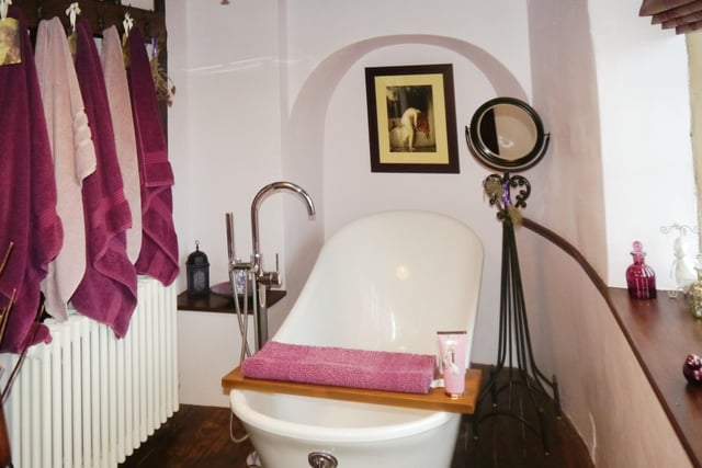 The bathroom is fitted with a three-piece suite comprising roll top slipper bath , wash hand basin and low-level WC.