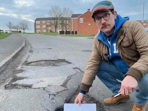 Coun Ed Fordham with one of the potholes he found.