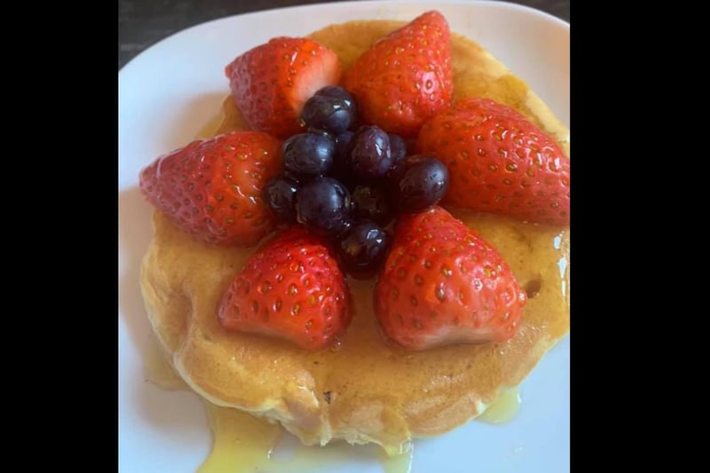 Fluffy pancakes topped with strawberries, blueberries and syrup. Lush.