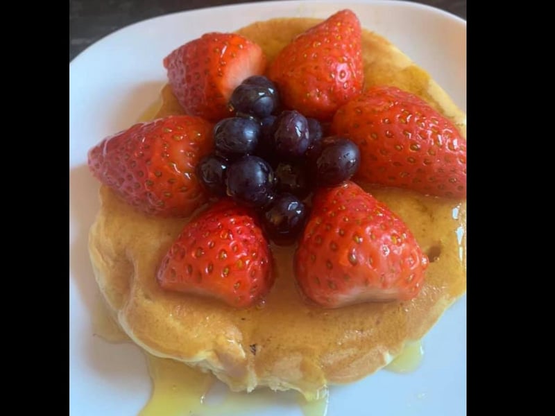 Fluffy pancakes topped with strawberries, blueberries and syrup. Lush.