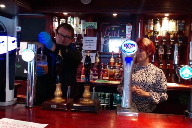 MP Mark Fletcher has a go at pulling a pint with Kay Towers after lockdown is lifted in August