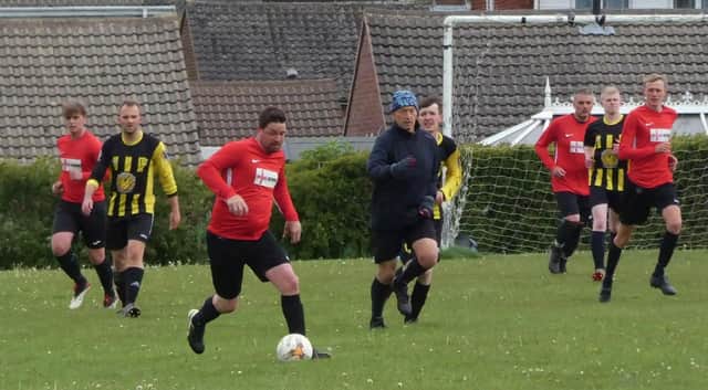 Action from the HKL Five clash between Gate Inn (red) and Hasland on Sunday. Photo: Martin Roberts.