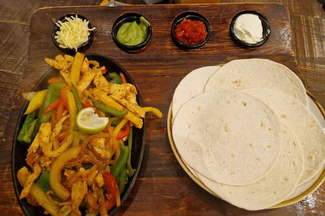 Fajitas were served on a large wooden board – with sizzling chicken, a mix of fried peppers and onions, as well as an array of dips including salsa, guacamole and sour cream.