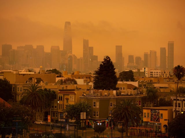 A hazy San Francisco skyline is seen from Dolores Park.