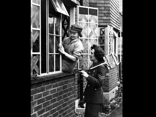 Cleaning windows. A member of the ATS cleaning windows while her squash-playing colleague stops for a chat.