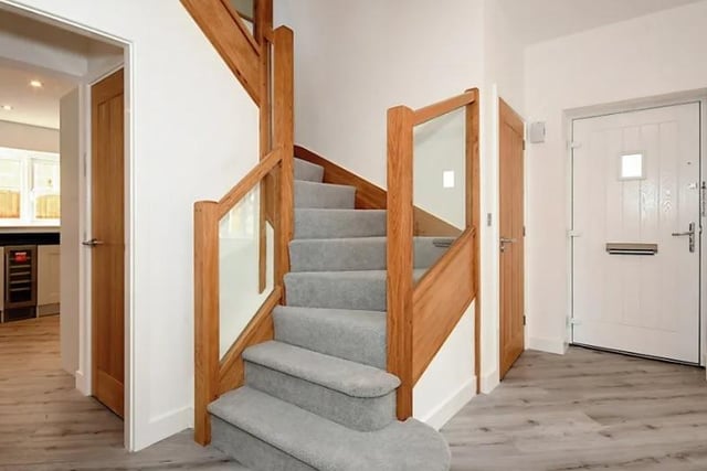 The staircase is made of oak and has glass infill panels.