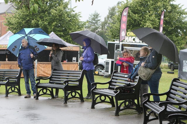 Residents gather under umbrellas to support the musicians playing live.