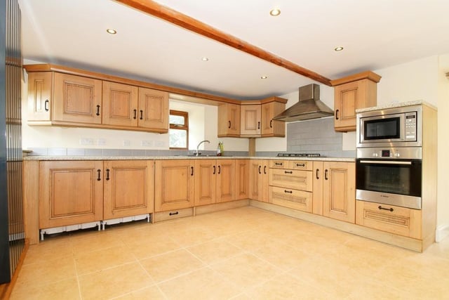Wall and base units in oak are contained within the spacious kitchen.