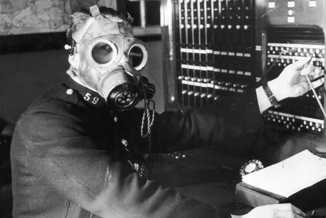 A Chesterfield Borough Police telephone operator tests a gasmask with built in earpiece and microphone in April 1939. The telephone service was considered one of the most important links in the coordination of ARP operations and needed to remain operational during air raids. (Photo by Fox Photos/Hulton Archive/Getty Images)