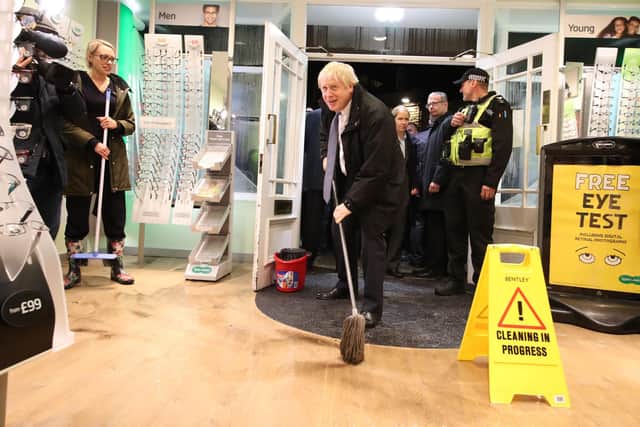 Boris Johnson helps with the clean up at Specsavers opticians in Matlock in 2019 after it was effected by flooding