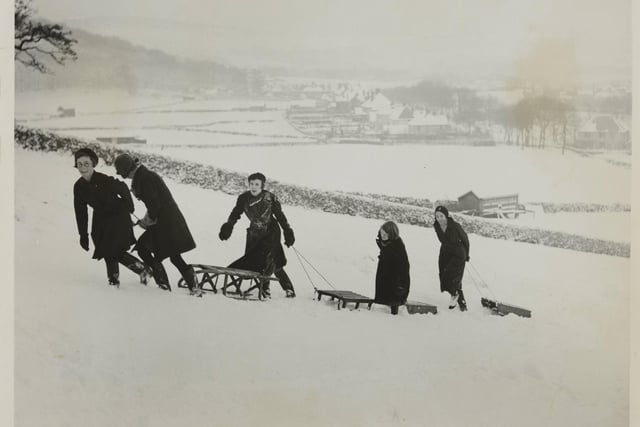 Winter sports in full swing in Buxton. A toboggan party climbing the slopes ready to take the famous run, in  December, 1900.