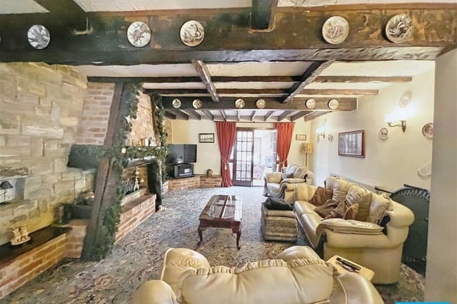 This spacious room offers a stone and brick fireplace that houses a gas fire. Eye-catching features include wooden beams to the ceiling and exposed stone to the walls.