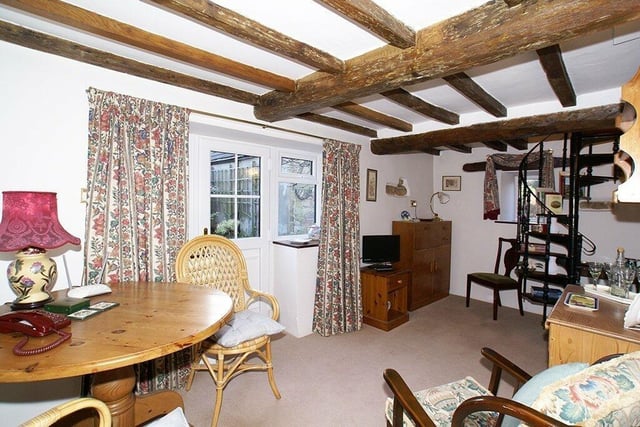The snug has original beams to the ceiling and a spiral staircase leading to the dressing room of the main bedroom.