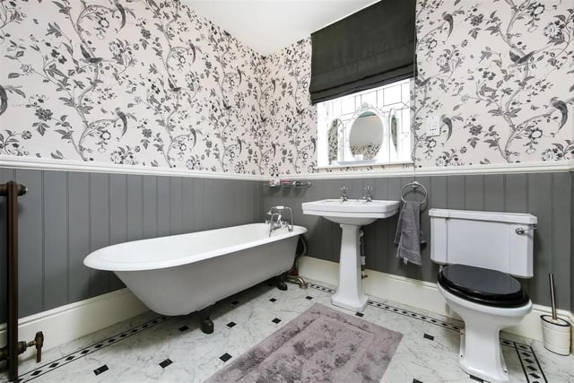 One of the bathrooms features a freestanding, roll top bath