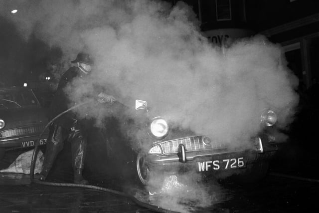 Police cadet Stephen Koral's cars engine catches fire in Cockburn Street in December 1965.