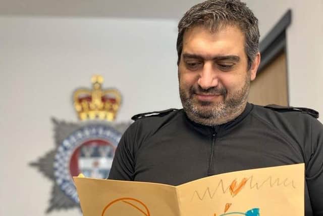 Assistant Chief Constable Kem Mehmet reading a thank you card