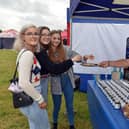 Rob Clayton, of  Blueberry Hill Preserves hands over some cheese to Libby Guy, Melissa Bibble and Zoe Dunbar to try at the Great British Food Festival at Hardwick Hall.