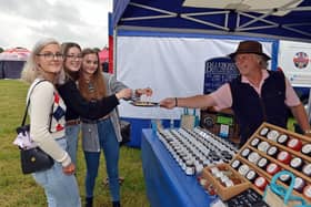 Rob Clayton, of  Blueberry Hill Preserves hands over some cheese to Libby Guy, Melissa Bibble and Zoe Dunbar to try at the Great British Food Festival at Hardwick Hall.