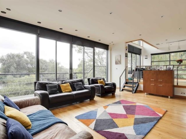 The living room has wood flooring with underfloor heating, a TV point, recessed spotlights, full height double glazed windows and double glazed sliding doors providing access to the balcony.