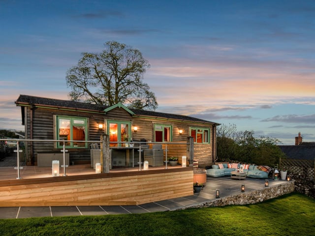 A cosy log cabin at Hoe Grange Holidays at dusk