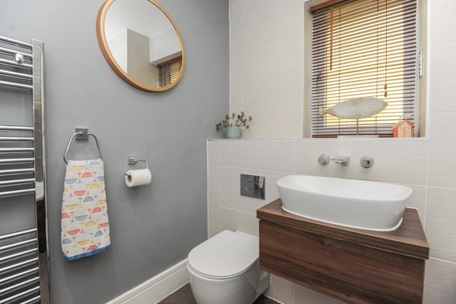 The bathroom is fitted with a white suite and includes a bath with overhead shower.