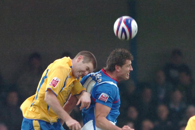 Jake Buxton tries to win a header against Steve Fletcher in a hard fought contest.