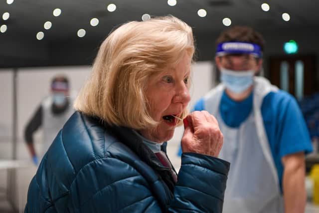 A woman takes the lateral flow test. Photo by Finnbarr Webster/Getty Images.