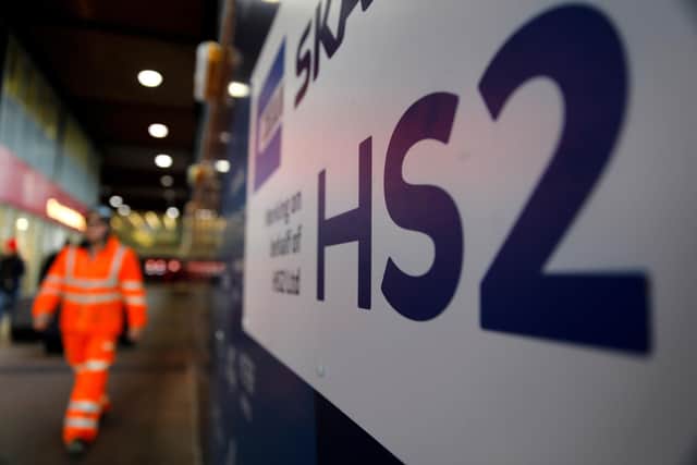 A worker walks past a sign outide a construction site for a section of Britain's HS2 high-speed railway project. (Photo by Tolga AKMEN / AFP) (Photo by TOLGA AKMEN/AFP via Getty Images)