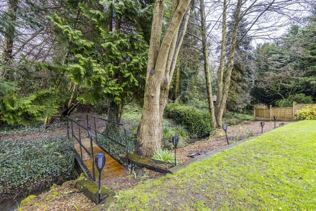 Beyond the rear garden is this footbridge, over a stream, that leads to enchanting woodland. It invites exploration with the kids, and connects the property to nature.