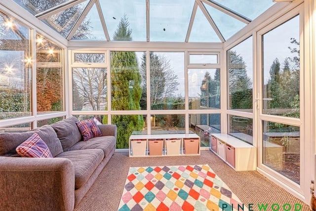 Overlooking the gardens, this lovely conservatory has built-in storage/bookcase.
