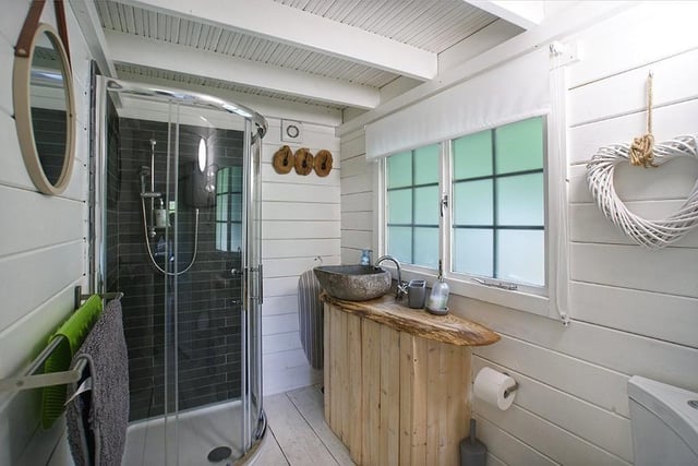 The guest cabin bathroom offers contemporary styling from the shower enclosure to the wash basin