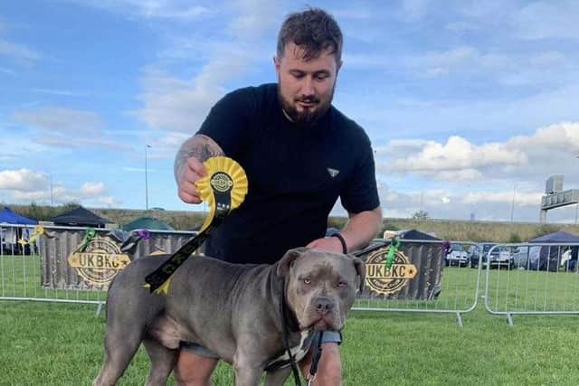 Charlea's partner Dylan Dennett, 27, with Bruce at a dog show - where he won a prize for obedience