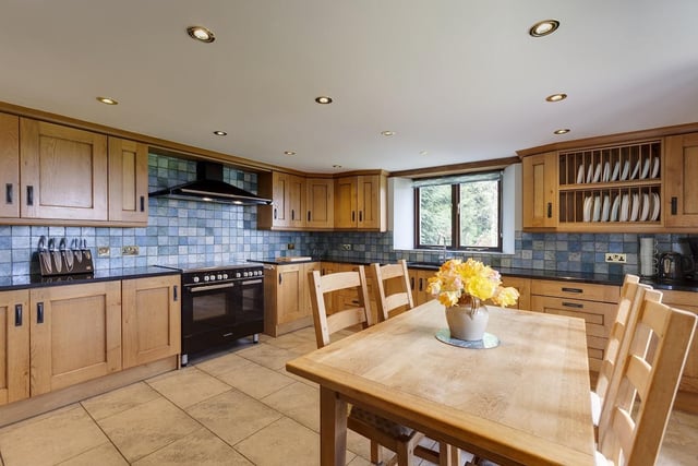 Within the kitchen that has fitted units and granite worktops, is a range cooker with five ring hob and two combination ovens, a dishwasher and a fridge-freezer.
