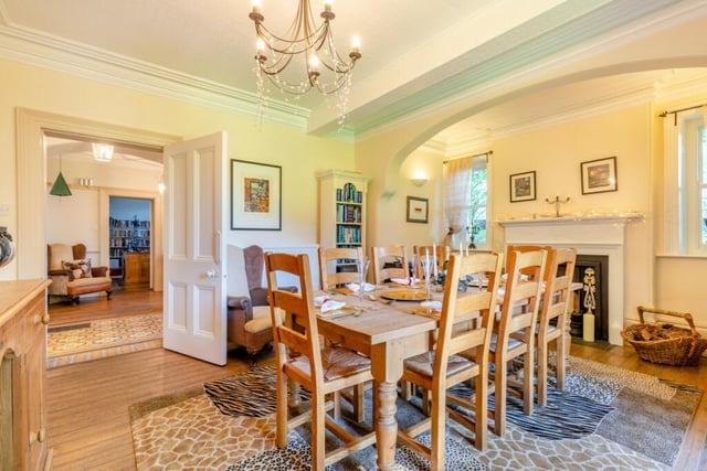 The formal dining room with decorative arch that frames the fireplace and windows.