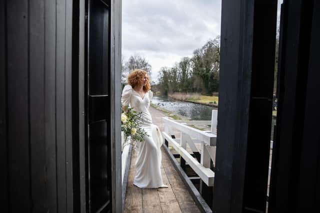 A bride looks out over Cromford Canal (photo: Sarita White Photography)
