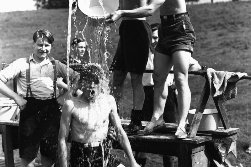 A boy having an improvised shower at Chatsworth Camp on 10 August 1939.  (Photo by Harry Shepherd/Fox Photos/Getty Images)