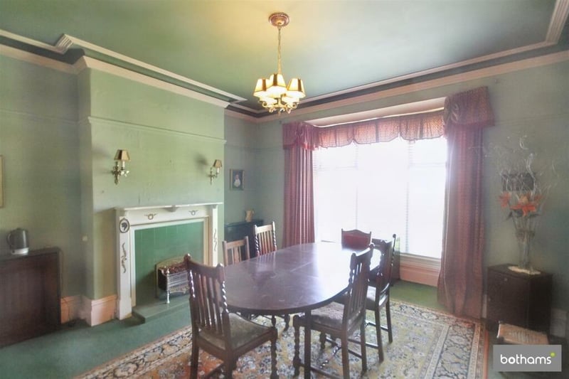 The dining room has a large bay window and a decorative fireplace.