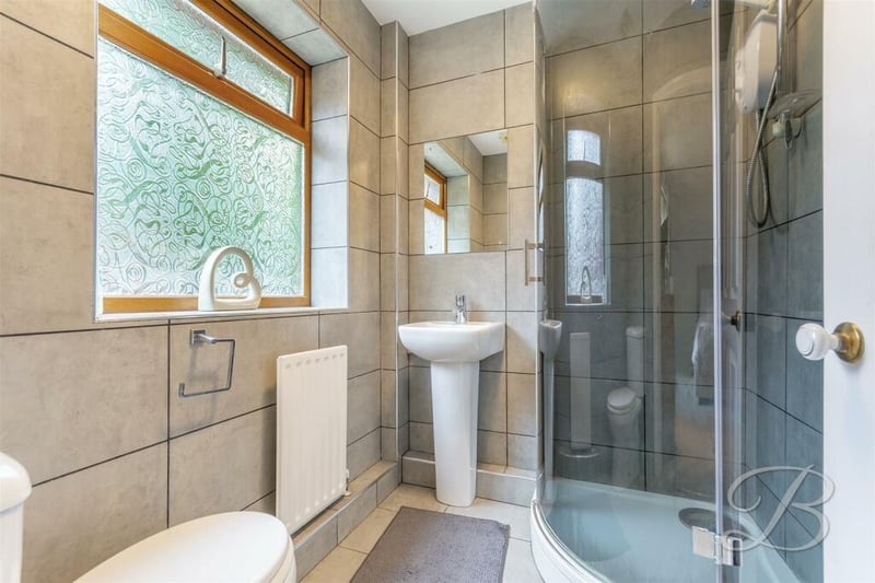 One of the bedrooms on the ground floor has access to this excellent en suite shower room. It has a curved walk-in shower cubicle, hand wash basin, low-flush WC and full-height tiling.