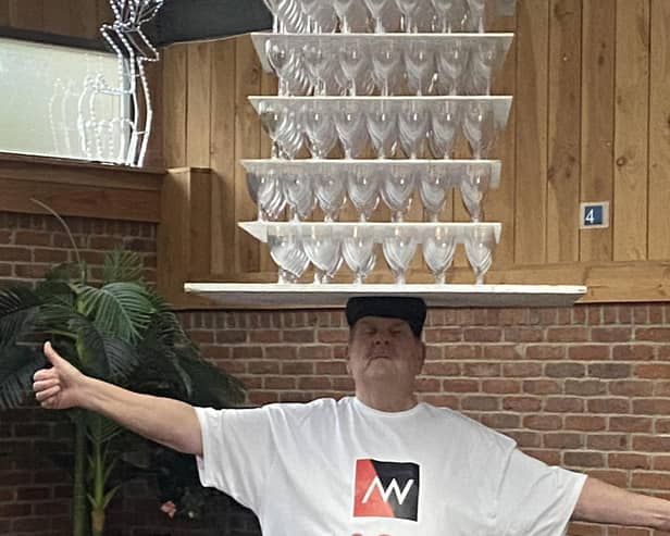 John Evans balanced 350 wine glasses on his head to claim the Guinness World Record.