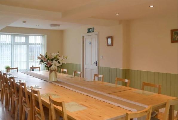 A large, welcoming room for guests to chat around a long table at mealtimes.
