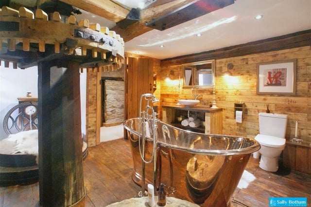 This exceptional bathroom has been lovingly created to retain the original mill workings, grinding stones, wooden flooring and beams.  A freestanding copper bath takes pride of place.