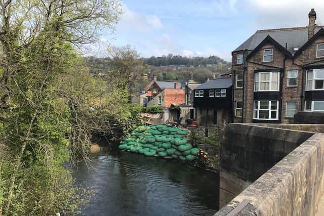 The river wall has been temporarily shored up with hundreds of bags of rock.
