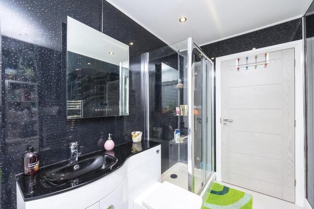 The eyecatching family bathroom sits on the ground floor of the dormer-style bungalow. A four-piece suite is made up of a panelled bath, double shower enclosure, wash basin and WC.