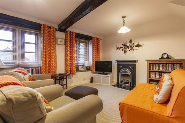 This double room is currently used as a sitting room and has original wooden beams, a fireplace with electric fire and two built-in storage cupboards.